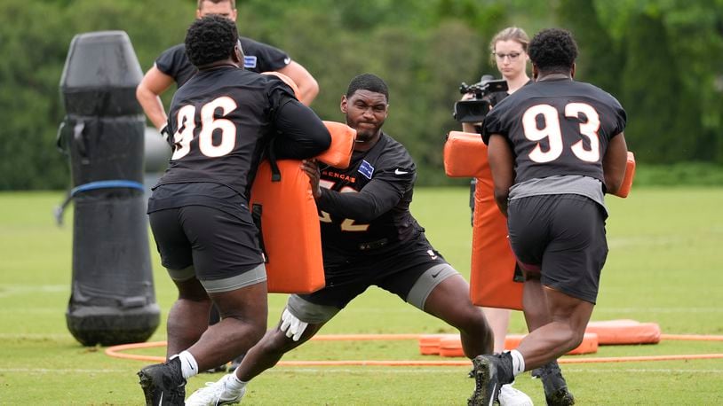 Cincinnati Bengals defensive end Cedric Johnson (52), center, with defensive ends Cam Sample (96) and Jeff Gunter (93) work a drill during the NFL football team's practice, Tuesday, May 14, 2024, in Cincinnati. (AP Photo/Carolyn Kaster)