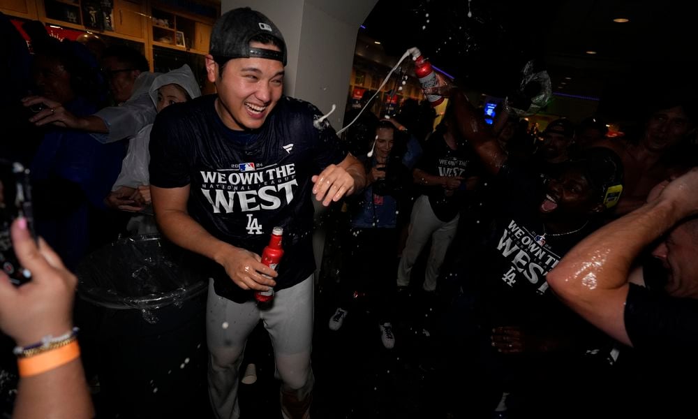 Los Angeles Dodgers designated hitter Shohei Ohtani celebrates with teammates after the Dodgers defeated the San Diego Padres 7-2 in a baseball game to clinch the National League West division Thursday, Sept. 26, 2024, in Los Angeles. (AP Photo/Ashley Landis)