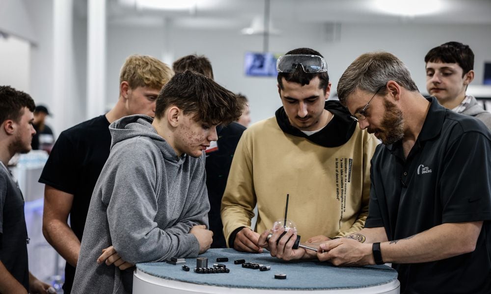 T.J. Vieira, right, a software technician for United Grinding in Miamisburg demonstrates how to measure the size of a bore. United Grinding held a manufacturing day in 2022 at the plant hosting seven school and over 200 high school students to learn about career paths in manufacturing. JIM NOELKER/STAFF